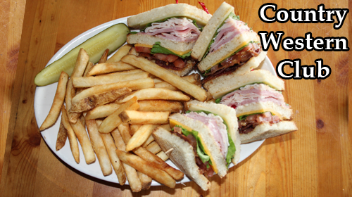 The Country Western Club: a triple-decker club sandwich quartered on a plate with fries and a pickle spear