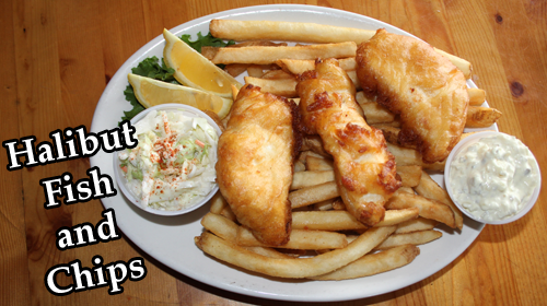 Halibut fish and chips: three golden beer-battered halibut pieces over fries with coleslaw, tartar sauce and lemon wedges
